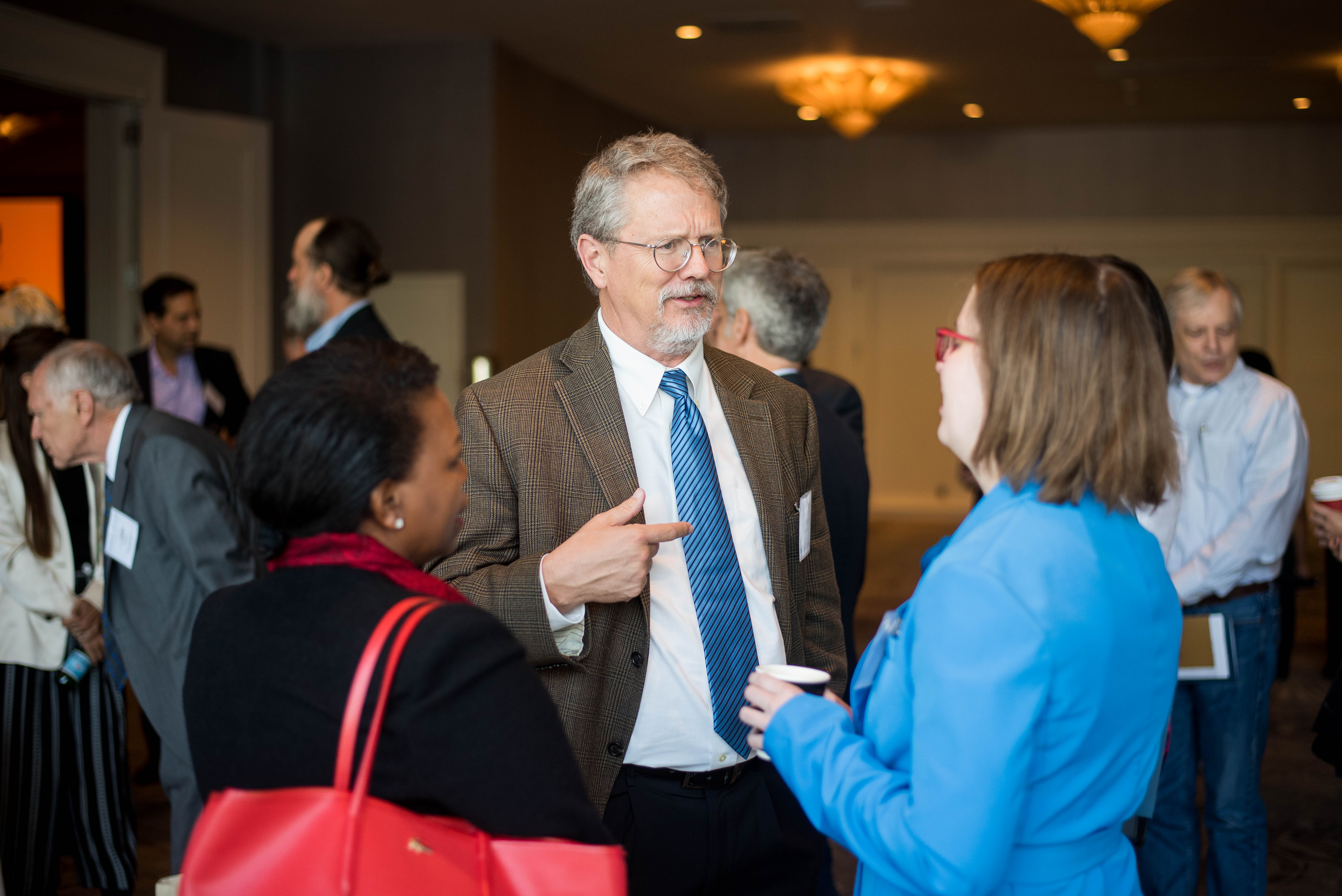 Three people speaking with one another at PolicyWest 2019